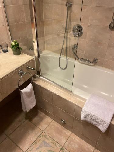 a bathroom with a shower and a white tub at Crowne Plaza Haifa by IHG in Haifa