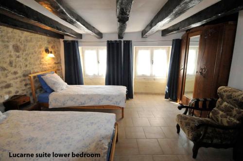 a hotel room with two beds and a chair at Le Passage in La Charité-sur-Loire