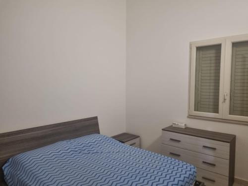 a bedroom with a bed and a dresser and a window at Casa vacanze appartamento Policoro ( Matera ) vicino al mare in Policoro