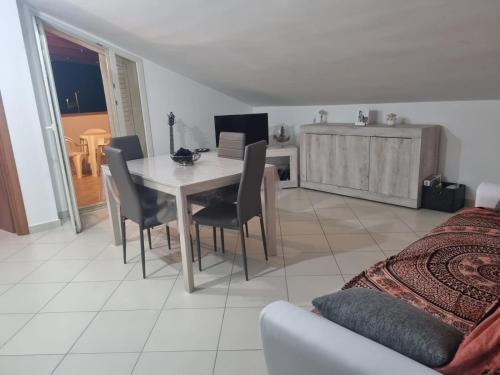 een woonkamer met een tafel en stoelen en een bed bij Casa vacanze appartamento Policoro ( Matera ) vicino al mare in Policoro