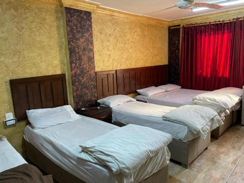 a group of four beds in a room at Aqaba Roza in Aqaba