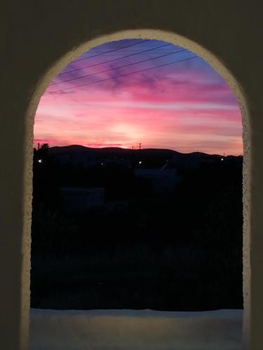 a view of a sunset through a window at Aliki Panorama Rooms -breakfast included- in Aliki