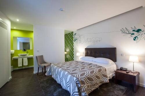 トーレ・デ・モンコルヴォにあるCasa Dona Maria Luizaの大型ベッドとシンクが備わるホテルルームです。