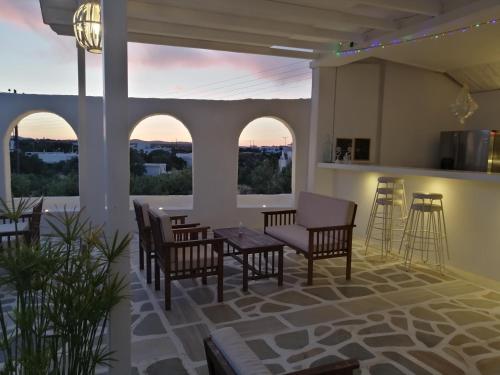 a patio with chairs and a table and some windows at Aliki Panorama Rooms -breakfast included- in Aliki