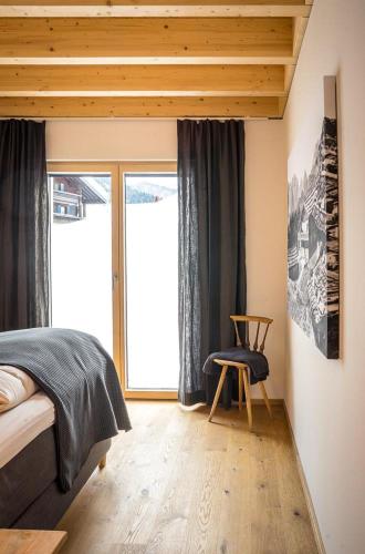 a bedroom with a bed and a window and a chair at Villa Wanderlust in Reit im Winkl