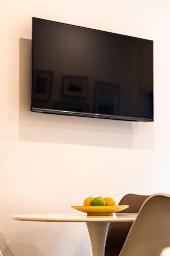 a plate of fruit on a table in front of a tv at Oliva Teles 53 - Sophia Terrace in Arcozelo