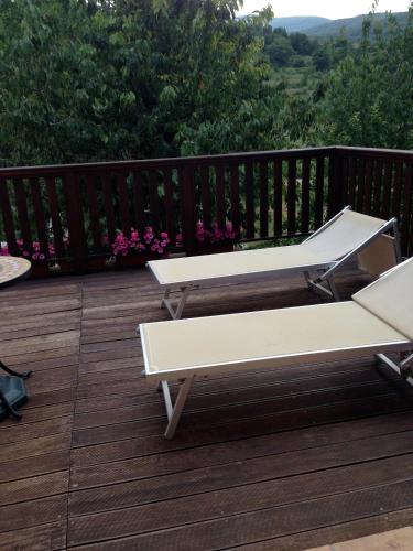 two white benches sitting on a wooden deck at Agriturismo Capriccio Di Giove in Cansano
