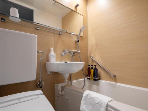 a bathroom with a sink, toilet, and bathtub at Fujieda Park Inn Hotel in Fujieda