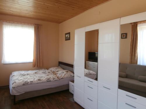 A bed or beds in a room at NATURA Vendégházak