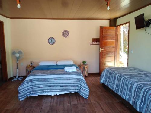 a bedroom with two beds and a fan at Bangalô Boa Ventura in Lumiar