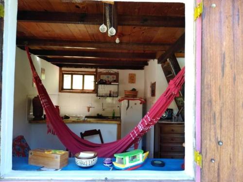 a room with a hammock in the middle of a kitchen at Bangalô Boa Ventura in Lumiar