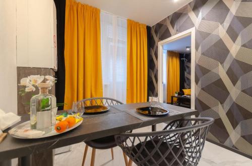 a dining room with a table and chairs and yellow curtains at Samira 2 in Kyiv