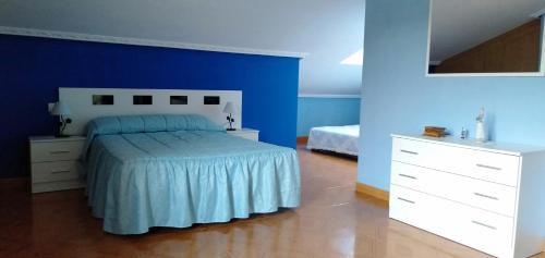 a blue bedroom with a bed and a white dresser at Casa Arregui in Gama