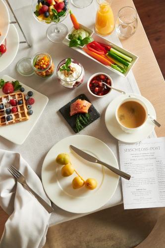 a table with plates of food and a cup of coffee at Seeschloss Sellin in Ostseebad Sellin
