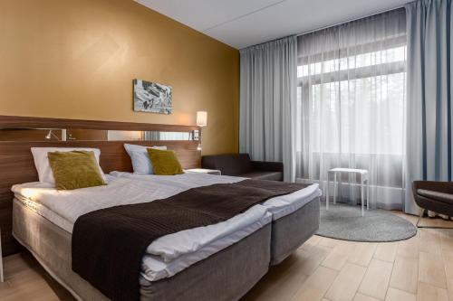 a hotel room with a large bed and a window at Holiday Club Vierumäki in Vierumäki