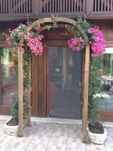 an arbor with pink flowers on it in front of a door at Agriturismo Capriccio Di Giove in Cansano