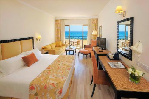 a hotel room with a bed and a living room at Elias Beach Hotel in Limassol