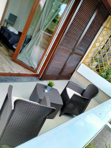 an outdoor patio with chairs and tables on a balcony at suite room malpensa b&b in Cardano al Campo