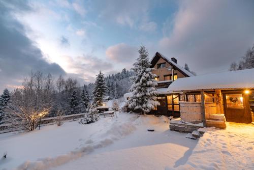 a house covered in snow in front at Bacówka u Winiarskich in Nowy Targ