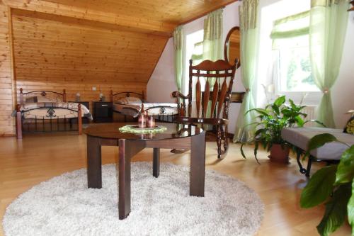 a living room with a table and a chair at Apartment Sotočje in Dolenja Trebuša