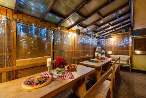 uma sala de jantar com duas mesas e luzes de Natal em Bacówka u Winiarskich em Nowy Targ