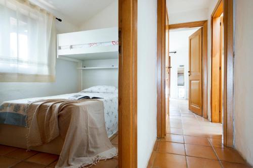 a bedroom with a bed and a open doorway at Infinite Blue Porto Cervo in Porto Cervo