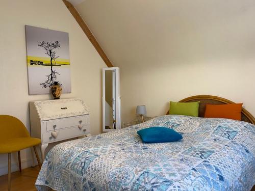 a bedroom with a bed with a blue pillow on it at Ty Ana in Ploubazlanec