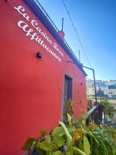 a red building with a sign on the side of it at La casina rossa Affittacamere in La Spezia