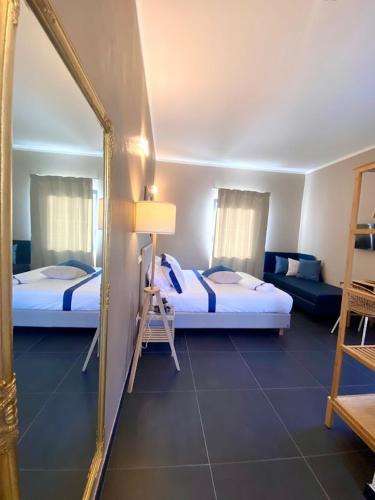 a hotel room with two beds and a mirror at La casina rossa Affittacamere in La Spezia