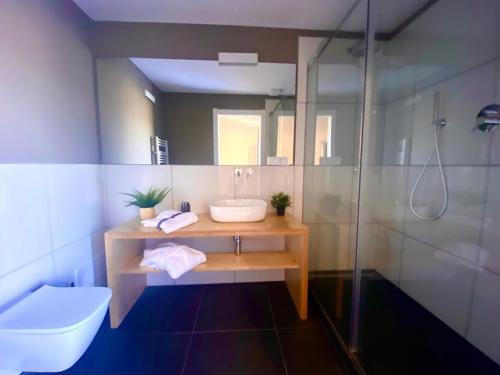 een badkamer met een wastafel en een douche bij La casina rossa Affittacamere in La Spezia