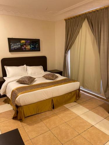 a bedroom with a large bed with a window at واحة المدينة للشقق الفندقيه in Al Madinah
