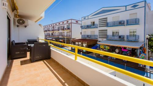 a balcony of a building with a yellow railing at Apartamento T2 na Praia da Alagoa in Altura