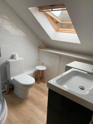 een badkamer met een wit toilet en een wastafel bij LE CHARME WIMEREUSIEN - lumineux - tout à pied in Wimereux