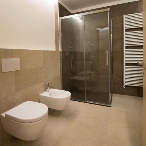 a bathroom with a toilet and a glass shower at Villa Berrettini in Marano Vicentino