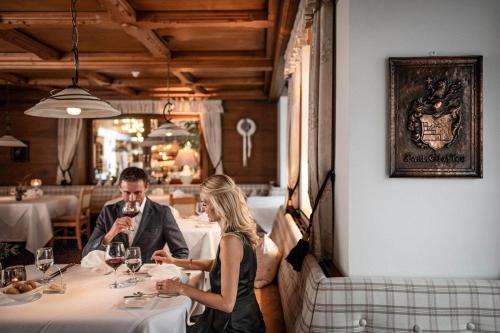 a man and a woman sitting at a table in a restaurant at Romantik Hotel & Restaurant Stafler in Vipiteno