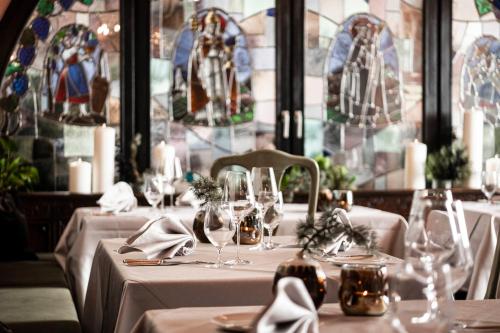 a table with glasses and napkins in a restaurant with stained glass at Romantik Hotel & Restaurant Stafler in Vipiteno