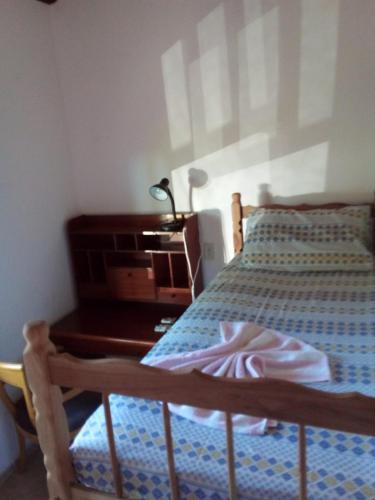 a bedroom with a bed and a desk with a lamp at Casa de Campo- no bosque c lareira elétrica in Jarinu
