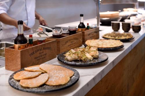 a buffet line with plates of food and bottles of wine at Holiday Inn & Suites - Dubai Festival City by IHG in Dubai