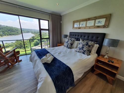 a bedroom with a bed with a teddy bear on it at Riverview Guesthouse East London in East London