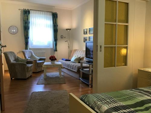 a living room with a couch and a tv at Ferienwohnung Ilse und Eberhard Tröps in Siegen