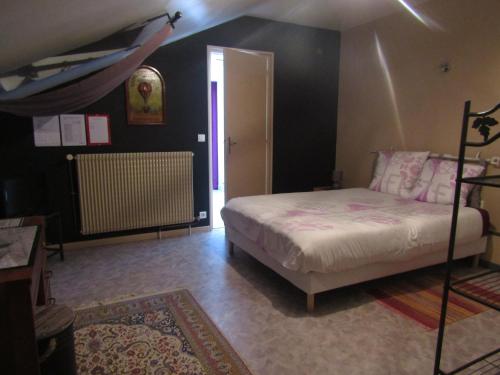 a bedroom with a bed and a room with a heater at suite familiale 2 chambre in Saint-Ouen-les-Vignes