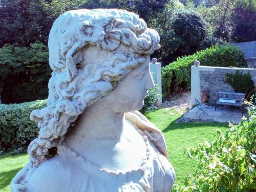 a statue of a woman in a garden at La Maison Jaffran, suite en ville in Privas