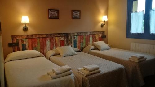 um quarto com três camas com toalhas em Casas Rurales Entrecastaños em Cangas de Onís