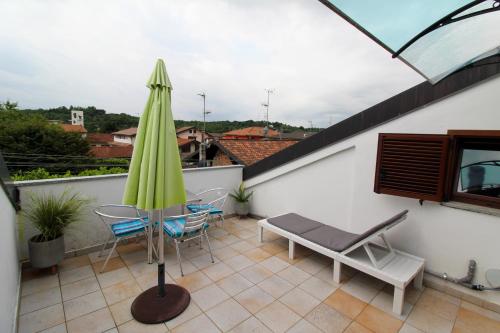 Un patio con una mesa y sillas y una sombrilla. en il faro di Manuela, en Fino Mornasco