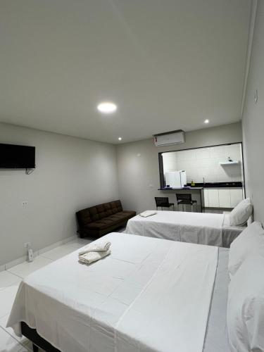 a hotel room with two beds and a couch at JH Flats in Maragogi