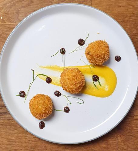 a white plate with some food on a table at Ring O Bells Hinton Blewett in Bristol