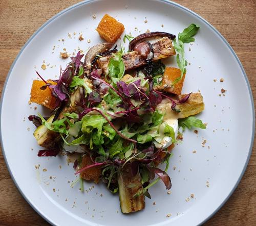 a white plate with a salad on a table at Ring O Bells Hinton Blewett in Bristol