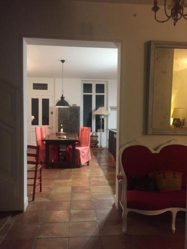 a dining room and living room with a table and chairs at La Maison du Port in Mortagne-sur-Gironde