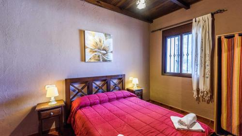 貝瑙漢的住宿－Casa La Mina Benaoján by Ruralidays，一间卧室设有红色的床和窗户。