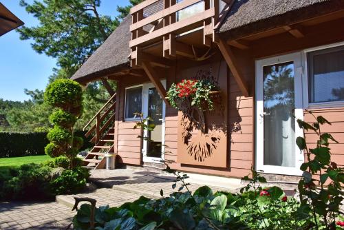 Neringa的住宿－Vila Deva，门上带花盆的粉红色房子